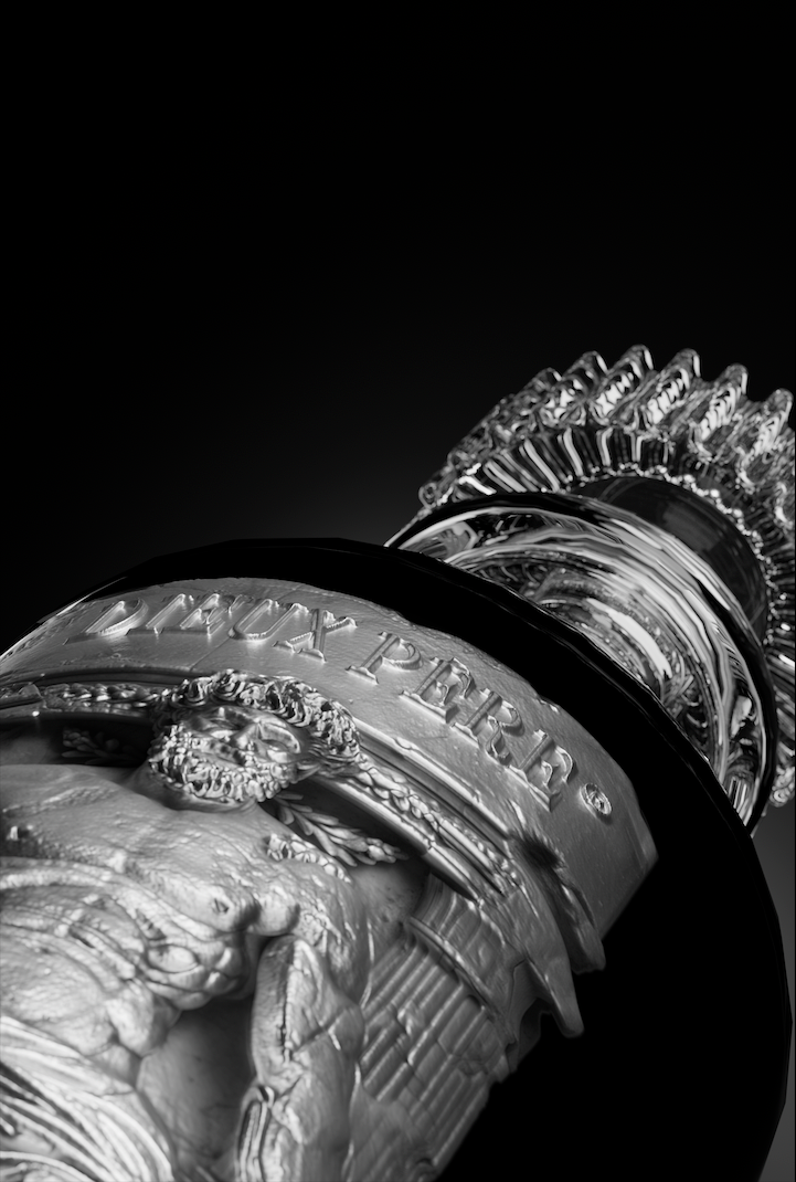 Close-up of the Maison Dieux Père metal label on the vodka macérat bottle.
